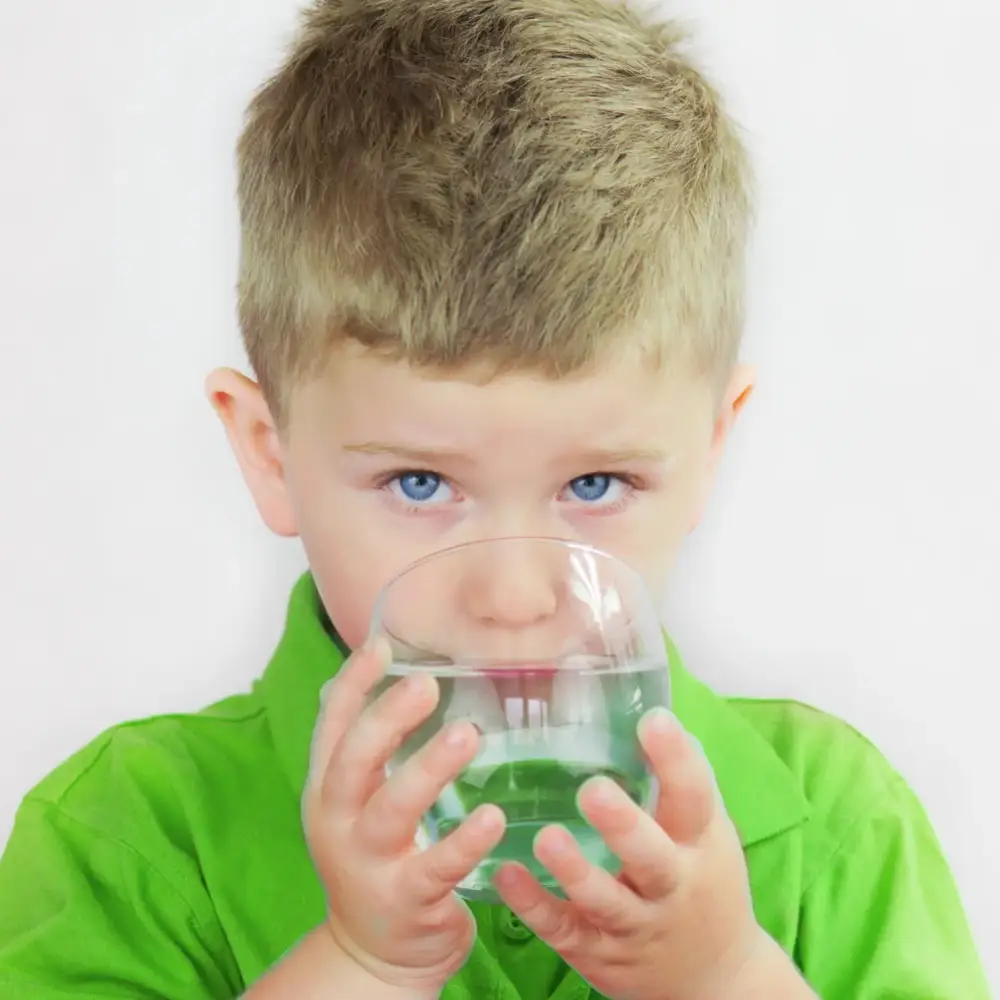 Young boy drinking a glass of clean water