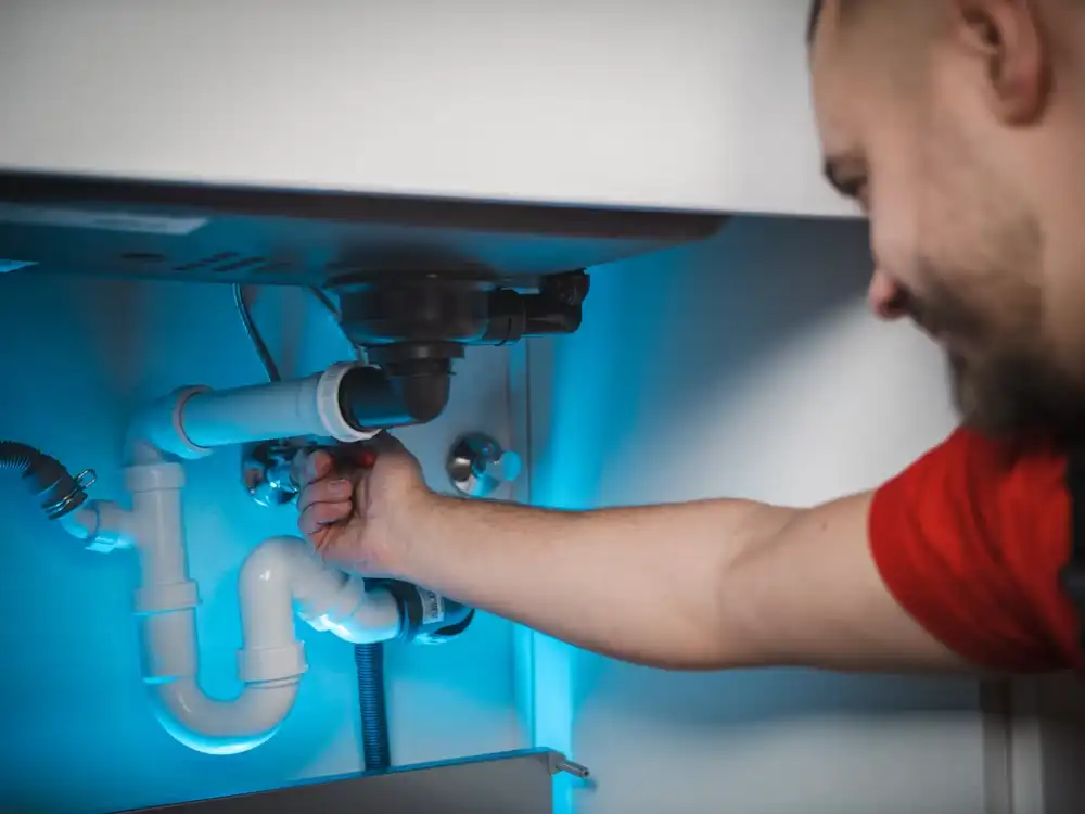 Technician installing plumbing under a sink