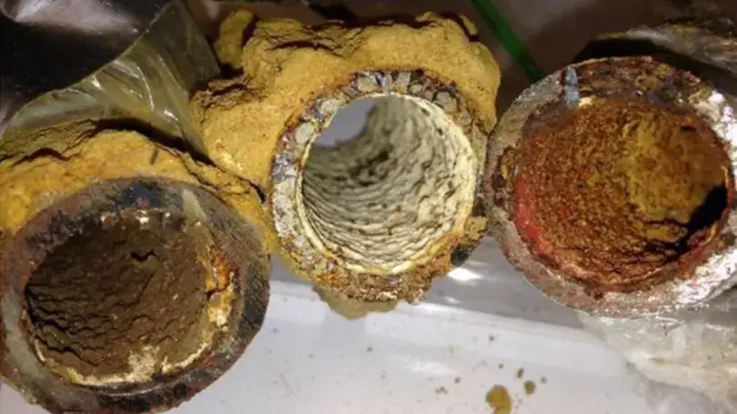 Cross-sections of household pipes nearly closed by hard-water scale and corrosion